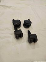 Four black twin-wheel casters showing stems and wheels