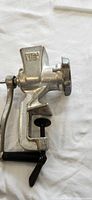 Side profile of the meat grinder showing crank handle and clamp