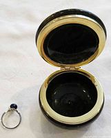 Ring beside open trinket box showing scale and interior