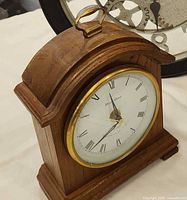 Front angled view showing wood case, brass bezel, handle, dial details