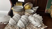 Group view of tea set showing cups, saucers, creamer and lidded dish