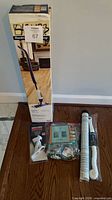 Group shot showing boxed Bona spray mop, flag bracket, hardware bag, shelf liner roll, decanter brush