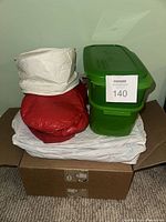 Stacked insulated bags and green rectangular containers on box