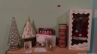 Overview of lot showing ceramic trees, ornaments, boxed doll, storage canister