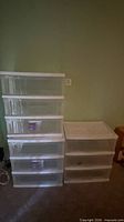 Left stack of three clear drawers in white frame with casters