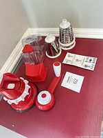 Entire set on countertop: base, crank, feed chute, collection container, three drums, instructions