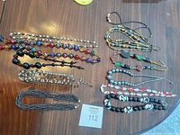 Overview of all 12 necklaces laid out on table