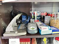 Shelf with hole punch, label maker, pens, clips, rubber bands