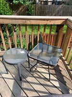 Round and square glass-top tables on deck