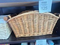 Wicker basket with wooden handles on shelf