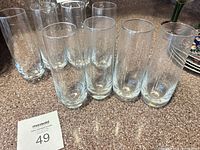 Front view of eight clear glass highball tumblers grouped together