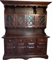 Front view of dark brown solid wood hutch showing glass doors, drawers and lower cabinets