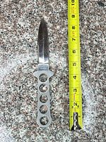 Full view of knife beside tape measure indicating blade length
