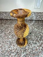 Full view of carved olive wood vase standing upright on countertop