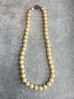 Full view of necklace laid flat showing strand and clasp