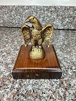 Front view of cast metal eagle on wooden base