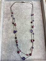 Full view of layered glass bead station necklace displayed flat