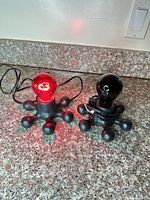 Both novelty lamps side by side, red bulb lit, black bulb unlit, showing overall design and cords