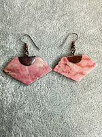 Full pair of pink stone earrings on fabric background