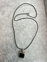 Full view of leather cord necklace with square pendant