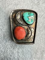 Front view of sterling silver bolo slide showing turquoise and coral stones