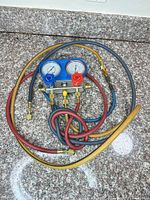 Top view of manifold gauge set with three hoses coiled