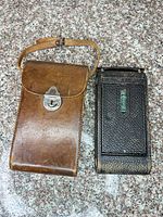 Camera and leather case side by side, closed position