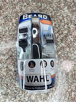 Front view of sealed Wahl beard trimmer kit in clamshell showing trimmer, guides, features