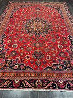 Full view of entire Persian Mashhad rug showing overall pattern and borders