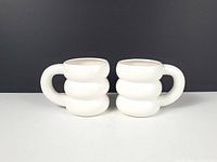 Front view of both white bubble mugs