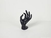 Front view of black matte hand display showing OK gesture and base