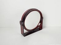 Front view showing round mirror in acrylic frame on stand