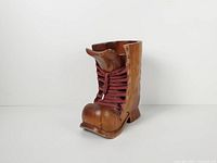 Front angled view of carved wooden boot vase showing laces and toe