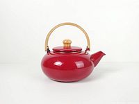 Front view of red enamel tea kettle showing handle and lid