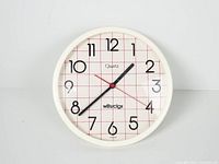 Front view of round white Westclox quartz wall clock
