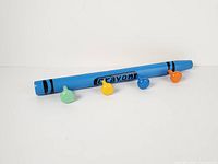 Full view of blue crayon rack showing four colored pegs
