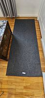 Dark grey rectangular floor runner rug laid flat on hardwood floor