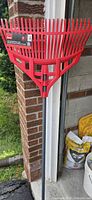 Full view of rake leaning against wall