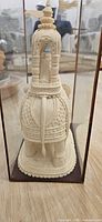 Rear view of ornate papier-mâché elephant inside case