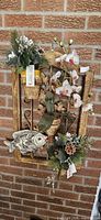 Full view of wood frame wall hanging with faux flowers and ceramic fish