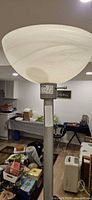 Upper section of floor lamp showing white swirled glass bowl shade and metal neck