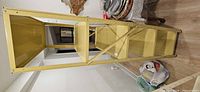 Overall view of beige metal shelving unit lying on its side, showing frame, shelves, and cross brace