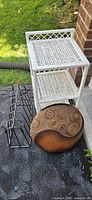 White wicker shelf, black metal rack, carved wooden box visible together