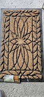 Full view of rectangular coir and rubber doormat with attached tag