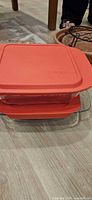 Two stacked glass containers with red lids