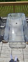 top view of glass patio table showing umbrella hole and metal frame