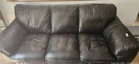 front view of dark brown leather sofa showing three cushions