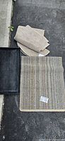Overview showing shoe tray, striped rug, round beige rug, and stack of beige rectangular rugs