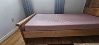 Side view of wooden twin bed frame and mattress