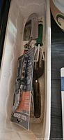 Tray holding pruning shears in package, hand trowel, weeder fork